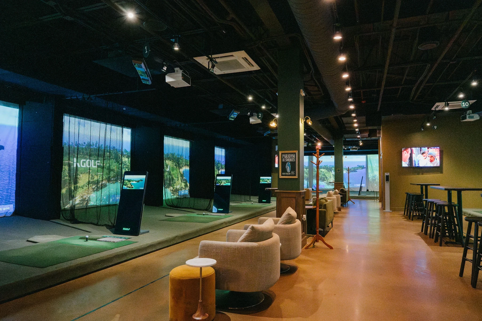 Commercial indoor golf venue with multiple KGOLF golf simulator bays and lounge seating